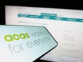 Cellphone with logo of Advisory, Conciliation and Arbitration Service (Acas) on screen in front of website. Royalty Free Stock Photo