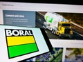 Cellphone with logo of Australian materials company Boral Limited on screen in front of business web page.