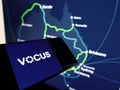 Cellphone with logo of Australian telecommunications provider Vocus Group Ltd on screen in front of website.