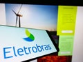 Cellphone with logo of Centrais ElÃÂ©tricas Brasileiras S.A. (Eletrobras) on screen in front of company website. Royalty Free Stock Photo