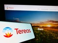 Cellphone with logo of French agriculture company Tereos S.A. on screen in front of business website.