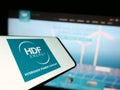 Cellphone with logo of French hydrogen company HDF Energy on screen in front of business website.