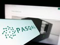 Cellphone with logo of French quantum processing company PASQAL SAS on screen in front of business website.