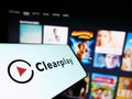 Cellphone with logo of parental control company Clearplay Inc. on screen in front of business website.