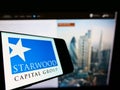 Cellphone with logo of US investment firm Starwood Capital Group LLC on screen in front of business website. Royalty Free Stock Photo