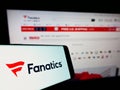 Cellphone with logo of US online sportswear retailer Fanatics Inc. on screen in front of business website. Royalty Free Stock Photo