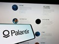 Cellphone with logo of US software company Palantir Technologies Inc. on screen in front of business website.