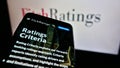 Cellphone with website of American credit rating agency Fitch Ratings Inc. on screen in front of company logo.