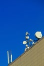 Cellular aerials against the vivid blue sky. Microwave transmission tower