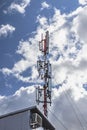Cellular antenna against a blue cloudy sky in a residential residential area. Modern communication technologies Royalty Free Stock Photo
