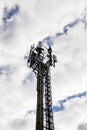 Cellular communications tower on cloudy sky background Royalty Free Stock Photo