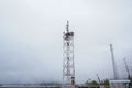 A cellular communications tower, with many antennas, in dense fog Royalty Free Stock Photo