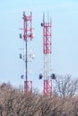 Cellular mobile communication towers in spring forest on blue sky background. Vertical landscape Royalty Free Stock Photo