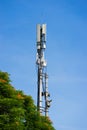 Cellular phone antena with blue sky and green tree background Royalty Free Stock Photo