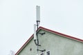 Cellular phone network telecommunication tower on the building roof Royalty Free Stock Photo