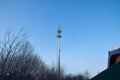 Cellular tower in village on winter sunny day or evening and blue sky background Royalty Free Stock Photo