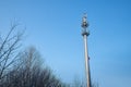 Cellular tower in village on winter sunny day or evening and blue sky background Royalty Free Stock Photo