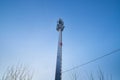 Cellular tower in village on winter sunny day or evening and blue sky background Royalty Free Stock Photo