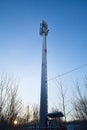 Cellular tower in village on winter sunny day or evening and blue sky background Royalty Free Stock Photo