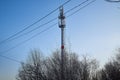 Cellular tower in village on winter sunny day or evening and blue sky background Royalty Free Stock Photo