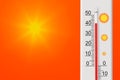 Celsius scale thermometer shows plus 42 degrees . Yellow sun in red sky.