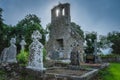 Celtic cemetery with sun star shining through ruined church tower