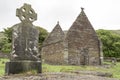 Celtic cross and ruin of church, Kilmalkedar Church and graveyard Ireland Royalty Free Stock Photo