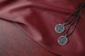 Celtic pendants on red silk cloth on leather book. Royalty Free Stock Photo