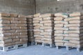 Cement bags in a row on the Palace in the shed. Royalty Free Stock Photo