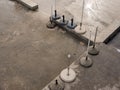 Cement beach sunshade bases with mounts and stems on cement surface under water top view