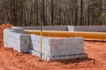 A cement block wall is constructed on the construction site to support the foundation of the house. Royalty Free Stock Photo
