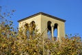 Cement building with decorative balcony and windows with no glass and copy space blue sky above dry season dead trees