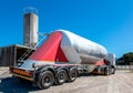 Cement delivery truck with multiple wheels and silo in background Royalty Free Stock Photo