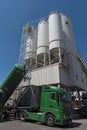 Cement factory with silos and green truck mixing silo construction site industry manufacturing