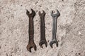 On the cement floor on the surface are different wrenches. Old rusty and shiny new tools. Inventory size mechanics Royalty Free Stock Photo