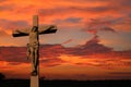 Cement life size cross with body of Jesus as sun sets