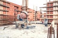 Cement mixer machine at construction site, tools, wheelbarrow, sand and bricks at house building.