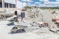 Cement mixer machine and wheelbarrow at building site Royalty Free Stock Photo