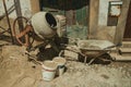 Cement mixer with pushcart and sand buckets in a construction site Royalty Free Stock Photo