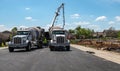 Cement mixers backed up to a concrete pump