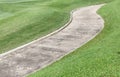 Cement path curving through green lawn in golf course. Royalty Free Stock Photo