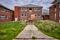 Cement path leading to entrance of large abandoned brick hospital buildings