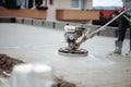 Cement smoothing trowel machinery with worker. screed, flooring smoothing at new house construction site