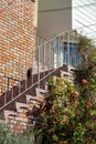 Cement stairs on side of house or building with blue metal hand rails and brick design with brick wall and home Royalty Free Stock Photo