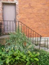 Stairway to door in brick wall with iron heart railing
