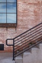 Cement steps and red brick wall with black handrail Royalty Free Stock Photo