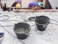 Cement tank for mixing mortar at a construction site with construction workers plastering the stairs Royalty Free Stock Photo