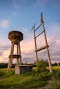 Water storage tank and electric pole and warehouse on field in rural Royalty Free Stock Photo