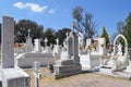 Cemetery with tombs, religious images, green trees and clear sky