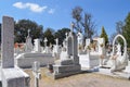 cemetery with tombs, religious images, green trees and clear sky